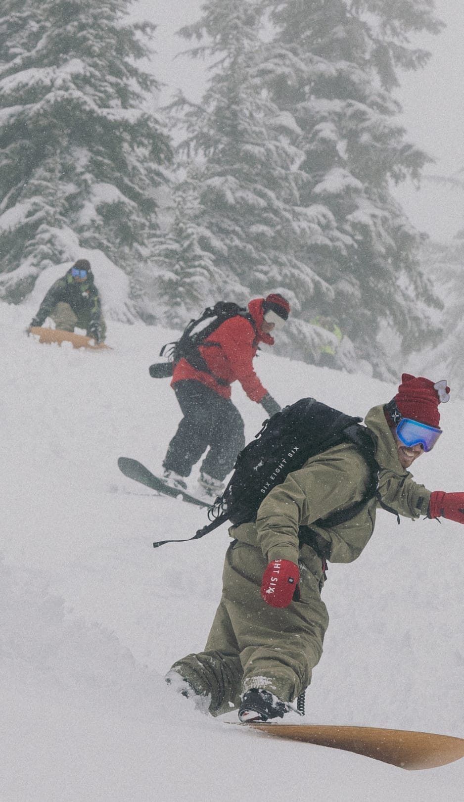 686 team riders snowboarding down a snowy mountain wearing an assortment of 686 gear.